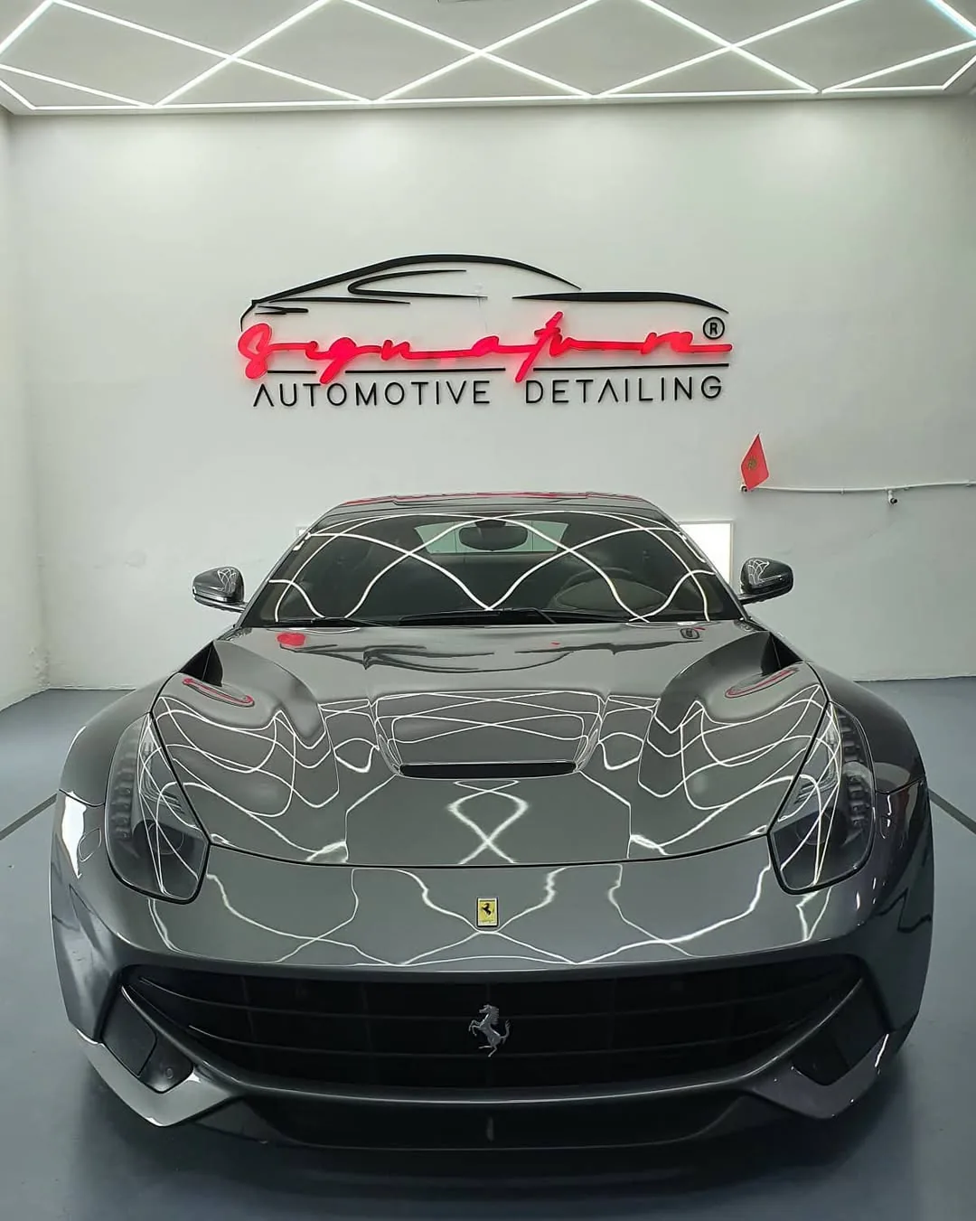 Ferrari F12 dans le studio de detailing Signature Auto Maroc sous un éclairage LED géométrique